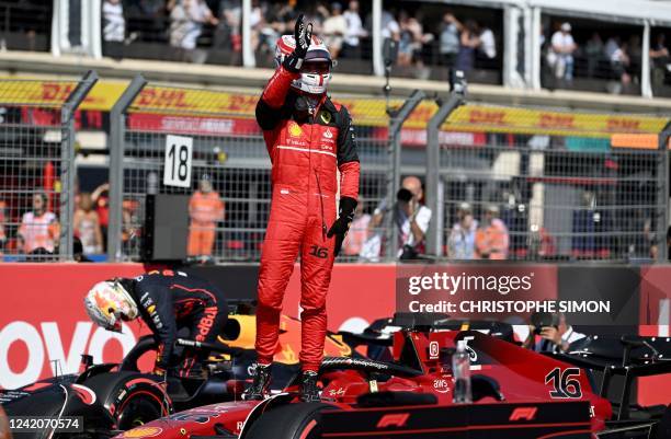 Ferrari's Monegasque driver Charles Leclerc salutes the crowd after he took the pole position during the qualifying session ahead of the French...