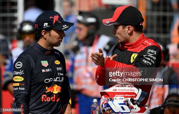 Ferrari's Monegasque driver Charles Leclerc talks with Red Bull Racing's Mexican driver Sergio Perez in the parc ferme after the qualifying session...