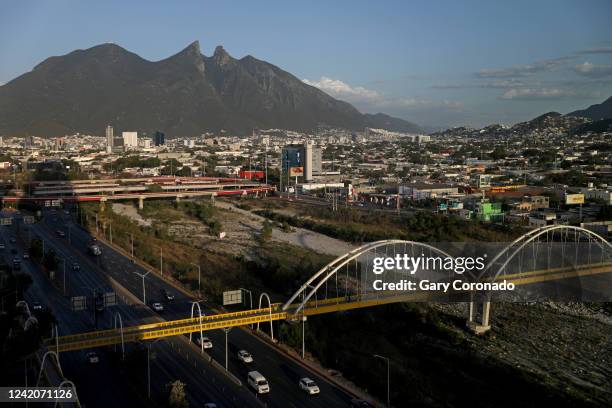 The Río Santa Cantarina shown in the foreground runs through the city center, with El Cerro de la Silla, in the background, part of the Sierra Madre...