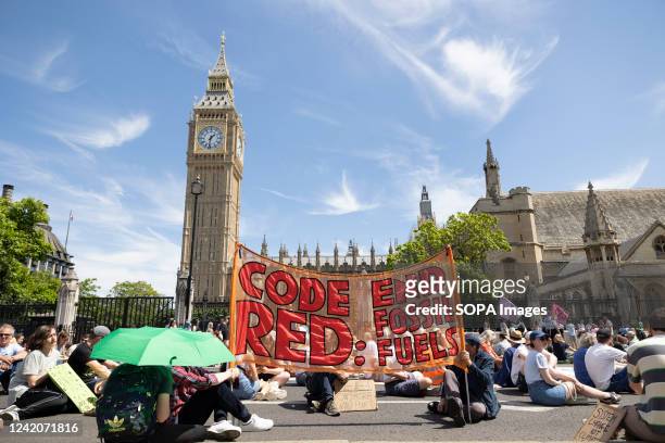 Protesters are seen sitting down in front of the UK Parliament during the demonstration. Multiple climate activists groups, including Just Stop Oil,...