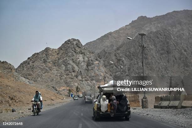Burqa-clad women sit in the back of a vehicle leading to Kandahar city on July 23, 2022.
