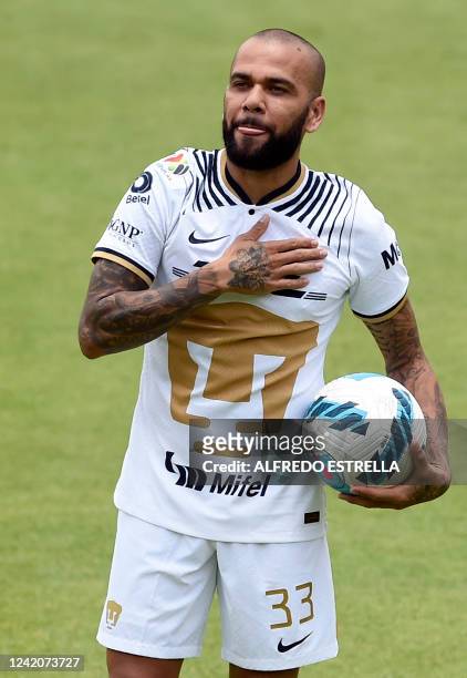 Brazilian international football star Dani Alves gestures during his presentation to the media after signing his contract for the current...