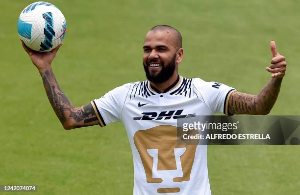 Brazilian international football star Dani Alves gestures during his presentation to the media after signing his contract for the current...