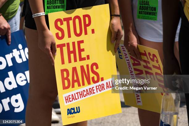 Protester holds a sign while marching and chanting through Downtown Atlanta, in opposition to Georgia's new abortion law on July 23, 2022 in Atlanta,...