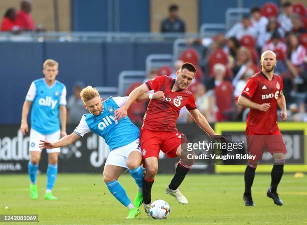 Kamil Jozwiak of Charlotte FC battles for the ball with Shane ONeill of Toronto FC during an MLS game at BMO Field on July 23, 2022 in Toronto,...