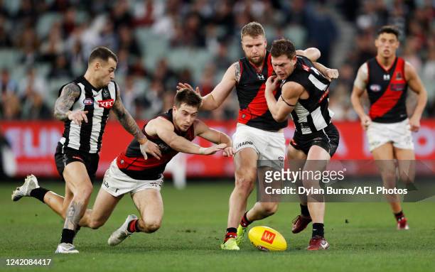 Jamie Elliott of the Magpies, Zach Merrett of the Bombers, Jake Stringer of the Bombers and Taylor Adams of the Magpies compete for the ball during...