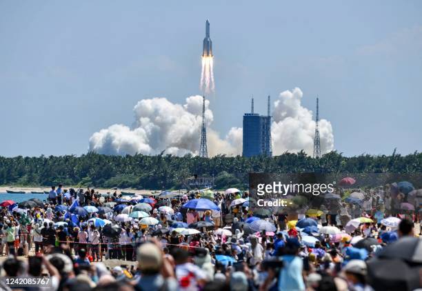 Onlookers watch the launch of a rocket transporting Chinas second module for its Tiangong space station from the Wenchang spaceport in southern China...