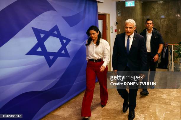 Israeli Prime Minister Yair Lapid and Interior Minister Ayelet Shaked arrive at the premier's office to attend a cabinet meeting in Jerusalem on July...