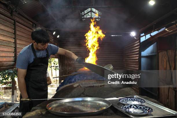 Bakers make "samsa", a savory pastry, in a traditional clay oven called tandoor in Almaty, Kazakhstan on July 11, 2022. Samsa, which is mentioned as...