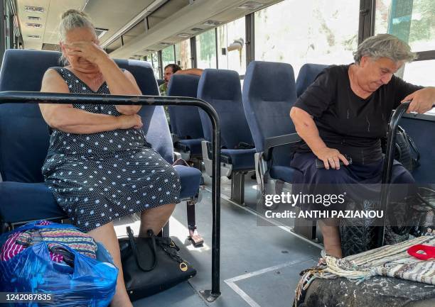 Eldery residents sit on a bus waiting for their evacuation in the village of Vrisa, in the southern part of the Greek island of Lesbos, as the...