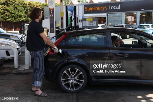 Driver refuels at a Sainsburys Local petrol station on July 24, 2022 in London, England. Many Supermarket Fuel Stations are still charging high...