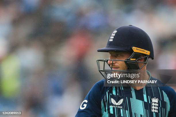 England's Jos Buttler reacts as he leaves the pitch as the rains falls and interrupts the third one-day international cricket match between England...