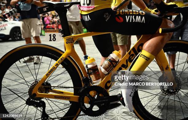 Jumbo-Visma team's Danish rider Jonas Vingegaard wearing the overall leader's yellow jersey sits on his bicycle as he awaits the start of the 21st...
