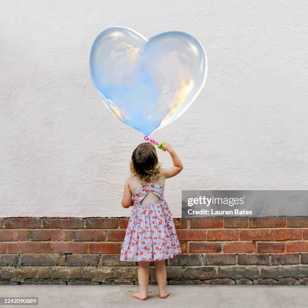 girl blowing heart bubbles - big bubble foto e immagini stock