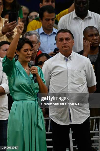 Brazil's President Jair Bolsonaro listens to his wife Michelle Bolsonaro during the Liberal Party national convention where he was officially...