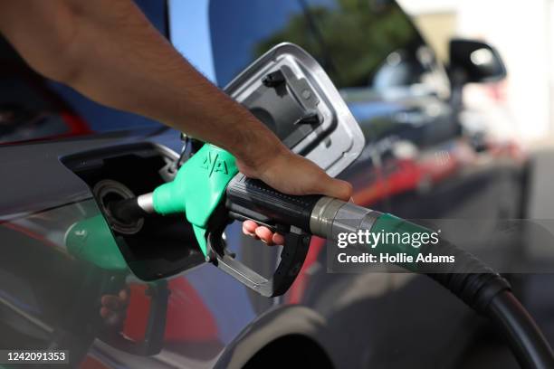 Driver pumps fuel at an Esso Tesco petrol station on July 24, 2022 in London, England. Many Supermarket Fuel Stations are still charging high prices...