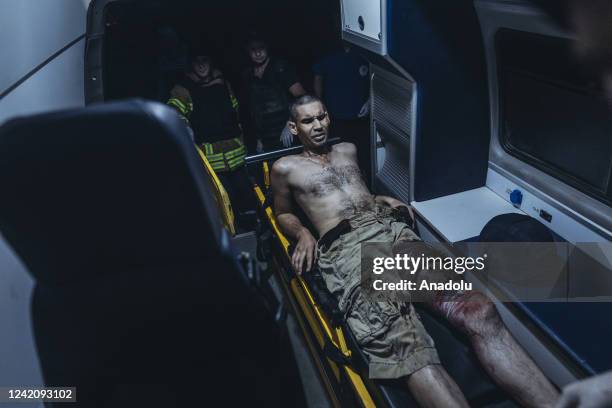 Emergency service personnel carry a civilian wounded by shelling to an ambulance in Bakhmut, Donetsk Oblast, Ukraine on July 24, 2022.