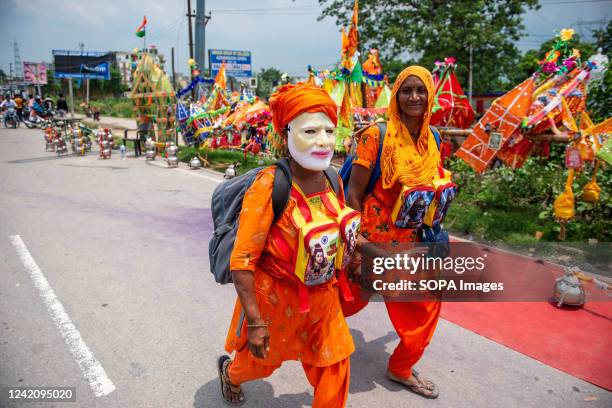 Kanwariya seen wearing a Narendra Modi mask and carrying holy water during annual Kanwar Yatra ahead of Shivratri festival on Delhi Meerut road,...