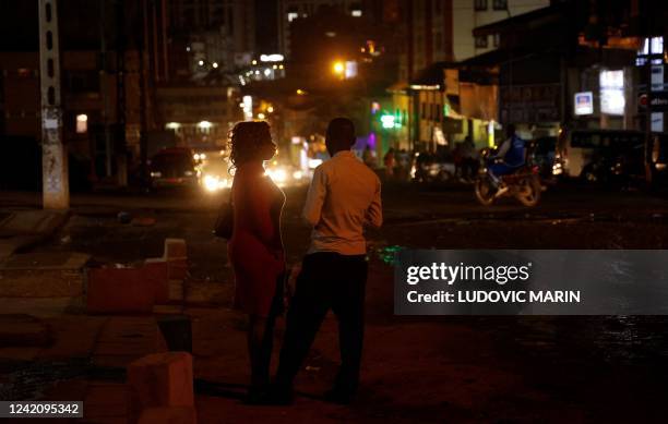 Couple stands in a street at night in Yaounde on July 24, 2022.