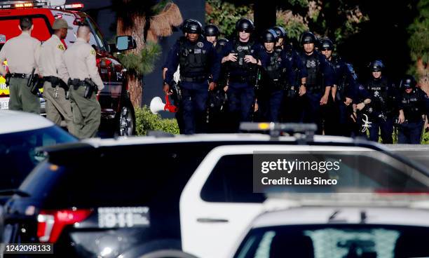 Officers and Sheriff's deputies stage at the entrance to Peck Park in San Pedro, where seven people were injured in a shooting on Sunday afternoon,...