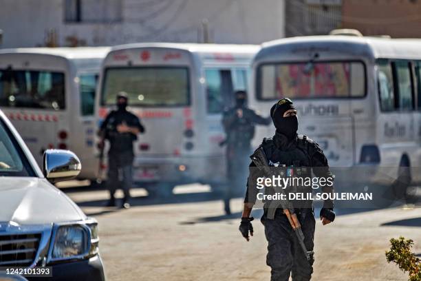 Members of Kurdish security forces deploy around buses carrying women and children from families of Islamic State fighters, after they were handed...