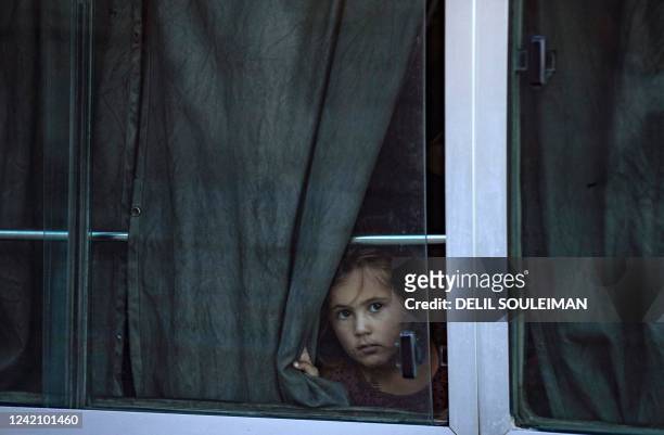 Women and children from families of Islamic State fighters sit in buses after Kurdish authorities handed them over to Tajikistan in Syria's...