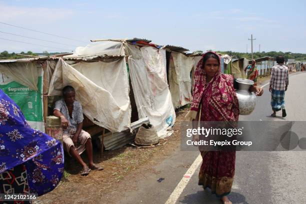 Flood-affected residents have taken shelter by building temporary huts on the roadside. On July 22, 2022 in Sylhet, Bangladesh.