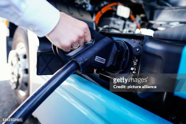 July 2022, Rhineland-Palatinate, Wörth am Rhein: An employee demonstrates how to charge a truck at the Mercedes-Benz Trucks KundenCenter during the...