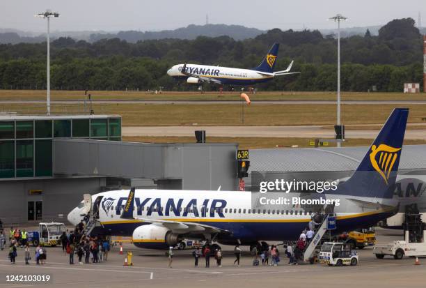Passengers board an aircraft, operated by Ryanair Holdings Plc, on the tarmac at London Stansted Airport, operated by Manchester Airport Plc, in...