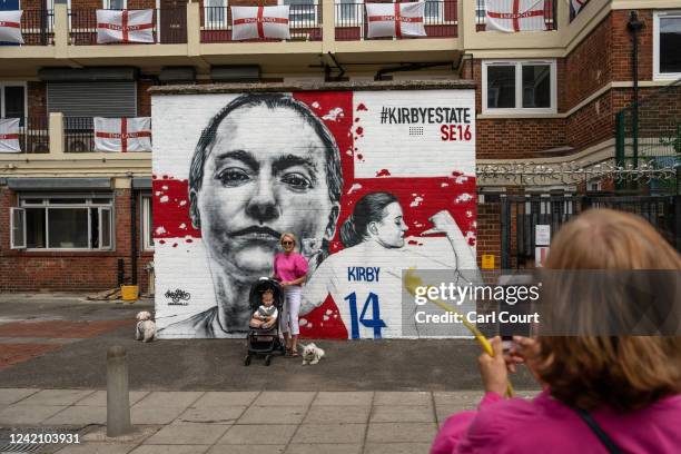 Woman has her photograph taken in front of a mural dedicated to England forward Fran Kirby on the Kirby Estate on July 25, 2022 in London, England....