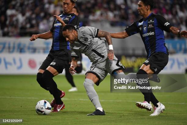 Neymar Jr of Paris Saint-Germain dribbles the ball under the pressure from Shota Fukuoka and Genta Miura of Gamba Osaka during the preseason friendly...