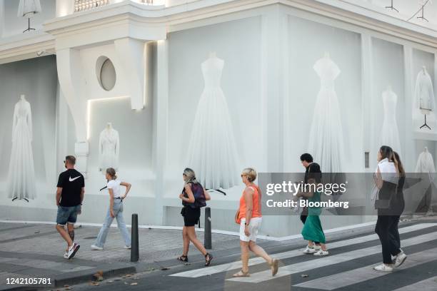 Pedestrians pass a Christian Dior SE luxury store on the Champs Elysees in Paris, France, on Sunday, July 24, 2022. French President Emmanuel...