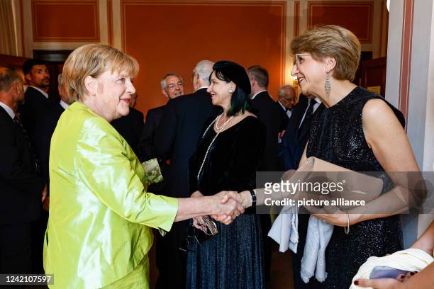 July 2022, Bavaria, Bayreuth: Former German Chancellor Angela Merkel welcomes French Ambassador Anne-Marie Descôtes to the Festival at the...