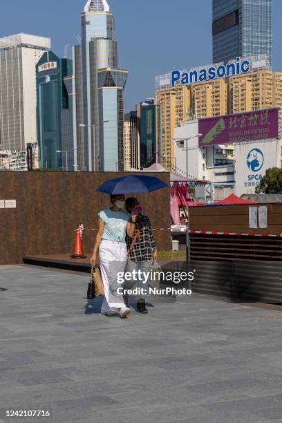 People shelter from the sun under umbrellas as a heatwave is hitting the norther hemisphere, in Hong Kong Hong Kong, S.A.R. Hong Kong, July 24, 2022.