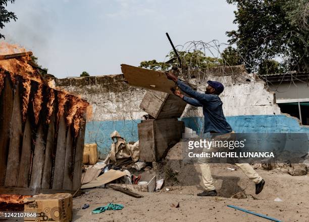 Protesters throw items into a burning barricade at the scene of a looted warehouse belonging to the peacekeeping mission in the Democratic Republic...