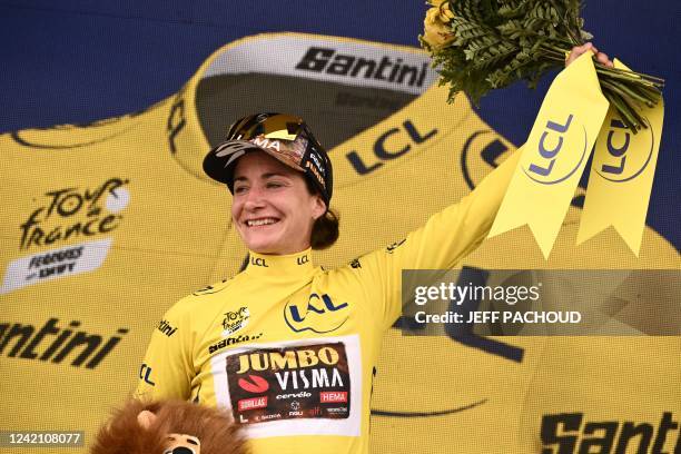 Team Jumbo Visma's Dutch rider Marianne Vos celebrates her overall leader yellow jersey on the podium at the end of the 2nd stage of the new edition...