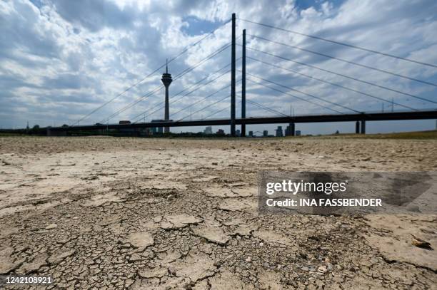 Dry soil of the partially dried-up river bed of the Rhine is pictured in Duesseldorf, western Germany, on July 25 as Europe experiences a heatwave.