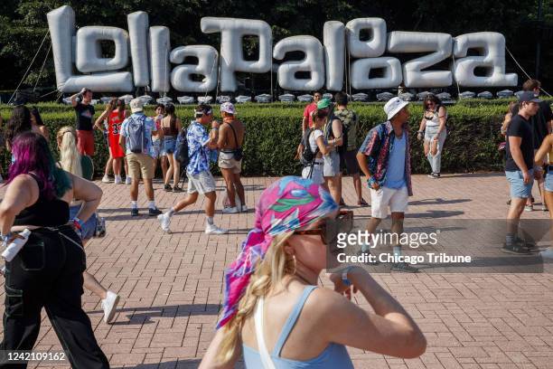 Attendees walk past a Lollapalooza sign during the first day of the annual music festival in Grant Park on July 29, 2021.
