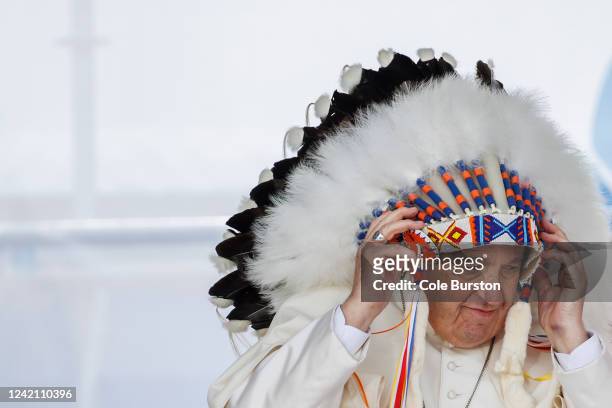 Pope Francis wears a traditional headdress that was gifted to him by indigenous leaders during his visit on July 25, 2022 in Maskwacis, Canada. The...