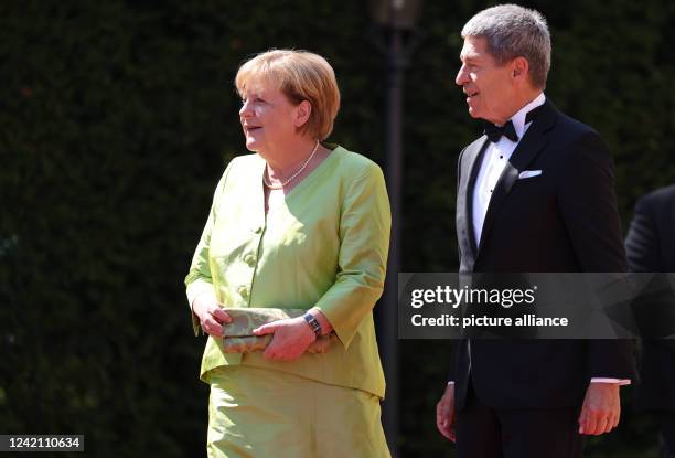 July 2022, Bavaria, Bayreuth: Angela Merkel, former German Chancellor, and husband Joachim Sauer arrive for the opening of the Bayreuth Richard...