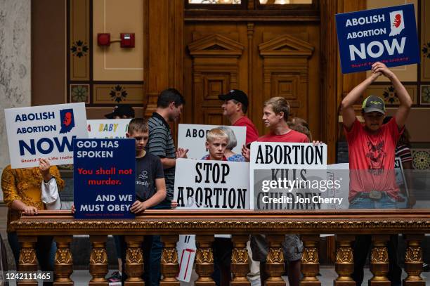 Anti-abortion protesters hold up signs inside of the Indiana State Capitol building on July 25, 2022 in Indianapolis, Indiana. Activists are...