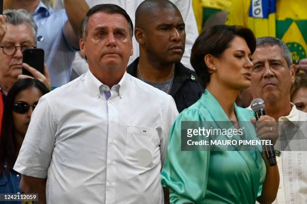 Brazil's President Jair Bolsonaro cries while his wife Michelle Bolsonaro delivers a speech during the national convention of the Liberal Party in...
