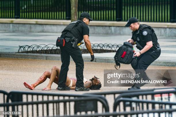 Graphic content / Members of the Secret Service render first aid after restraining a woman on Pennsylvania Avenue in front of the White House on July...