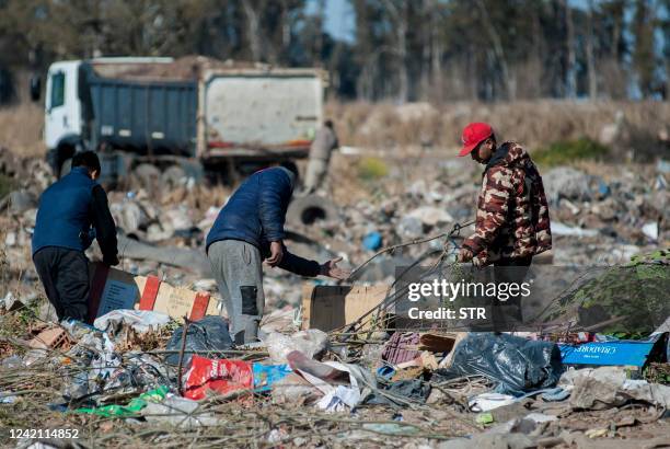 People look for dollar notes among the garbage, in the dump of Las Parejas, Santa Fe province, Argentina on July 20, 2022. $100 bills that were blown...