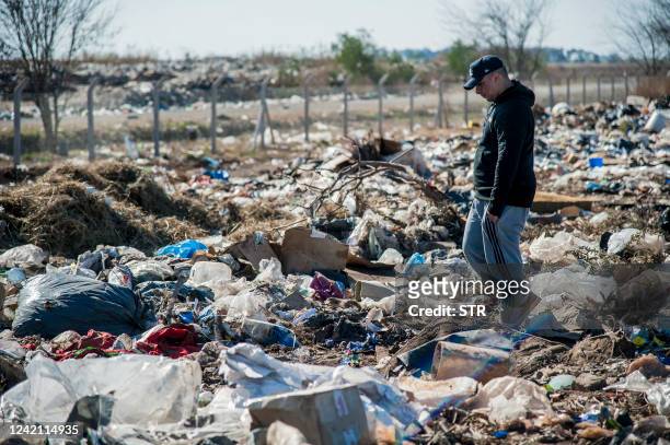 People look for dollar notes among the garbage, in the dump of Las Parejas, Santa Fe province, Argentina on July 20, 2022. $100 bills that were blown...