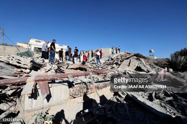 People gather after Israeli forces demolished the home of Palestinian militant Yehya Miri, accused of carrying out a deadly shooting attack in the...