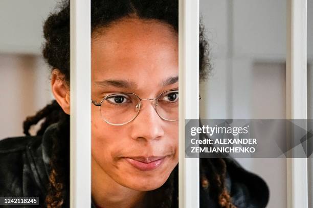 Basketball superstar Brittney Griner looks from inside a defendants' cage before a hearing at the Khimki Court, outside Moscow on July 26, 2022. -...