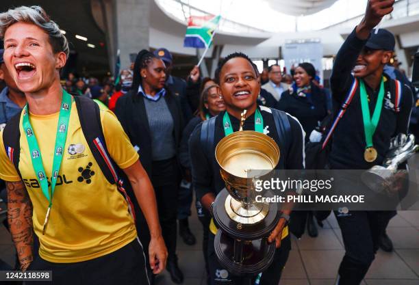 South African senior national women's team players Janine van Wyk , captain Refiloe Jane and goalkeeper Andile Dlamini react as they arrive at OR...