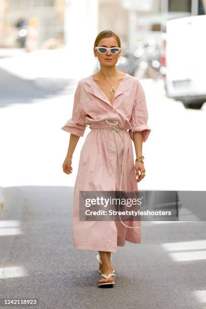 Influencer Anna Borisovna, wearing a rosa maxi dress by Mango, a leather belt by "nCos, gold alphabet necklace by Celine and cat-eye white sunglasses...