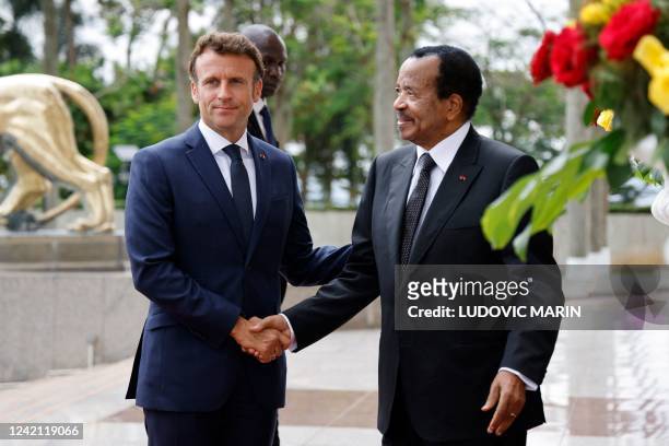 France's President Emmanuel Macron shakes hands with Cameroon's President Paul Biya as he arrives for talks at the Presidential Palace in Yaounde, on...